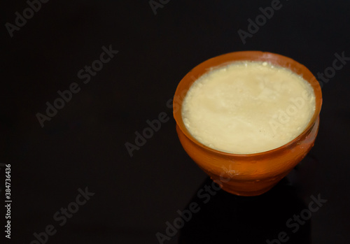 Sweet curd or dahi in hindi, or Mishti Doi in Bengali, served in earthen pot with White Background. Selective focus is used. photo