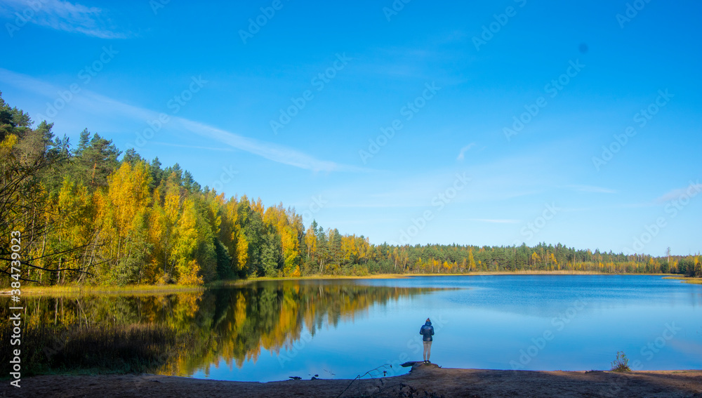 loneliness in nature - a man by a forest lake