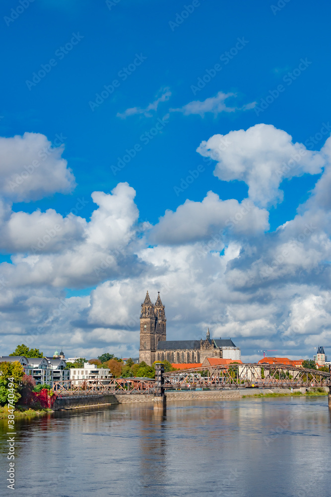 Historical and shopping downtown of Magdeburg, old town, Elbe river and Magnificent Cathedral at early Autumn, Germany, with heavy clouds and blue sky.