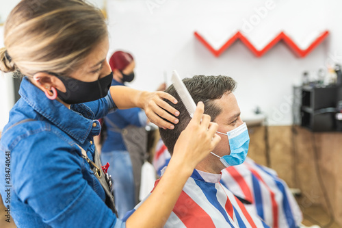 Barber Woman Cutting Man Hair at the Barbershop Wearing Mask.