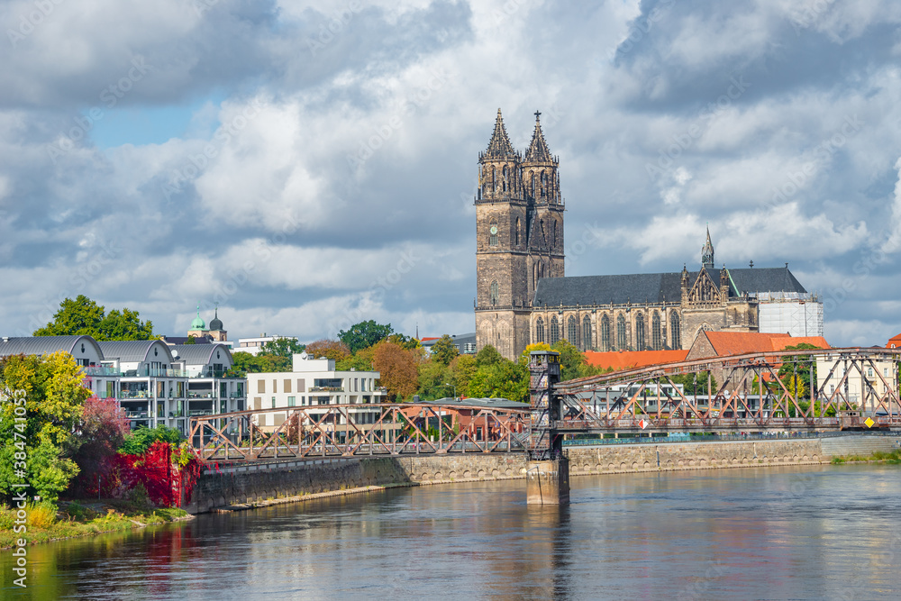 Historical and shopping downtown of Magdeburg, old town, Elbe river and Magnificent Cathedral at early Autumn, Germany, with heavy clouds.