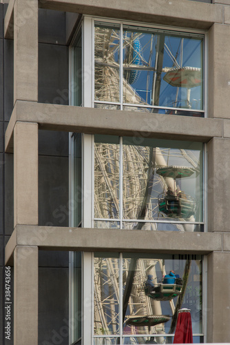 Glasfassade in Köln mit spiegelnden Riesenrad