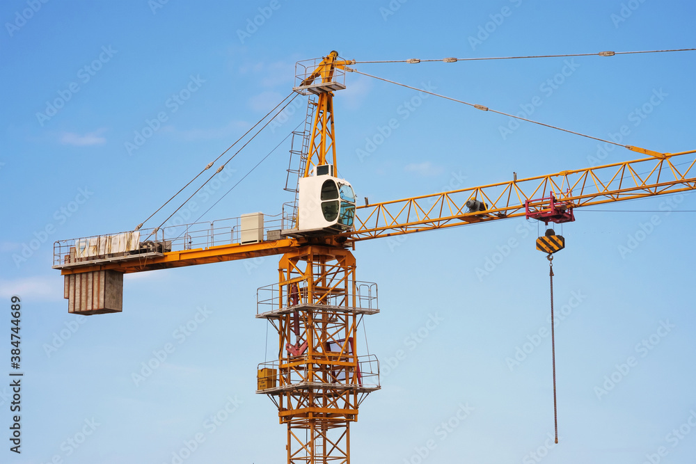 Construction tower crane on a blue sky background Construction tower crane on a blue sky background