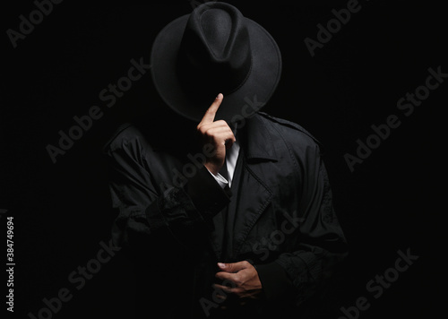 Old fashioned detective in hat on dark background