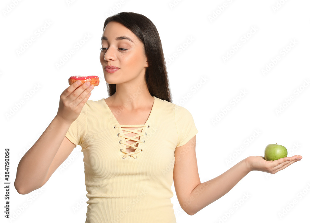 Concept of choice. Woman eating doughnut and holding apple on white background