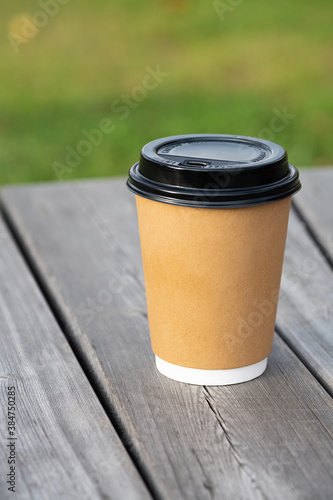 Yellow paper coffee cup on wooden surface for coffee and go service.