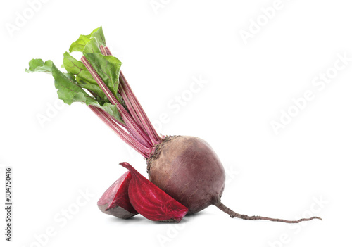 Whole and cut red beets on white background photo