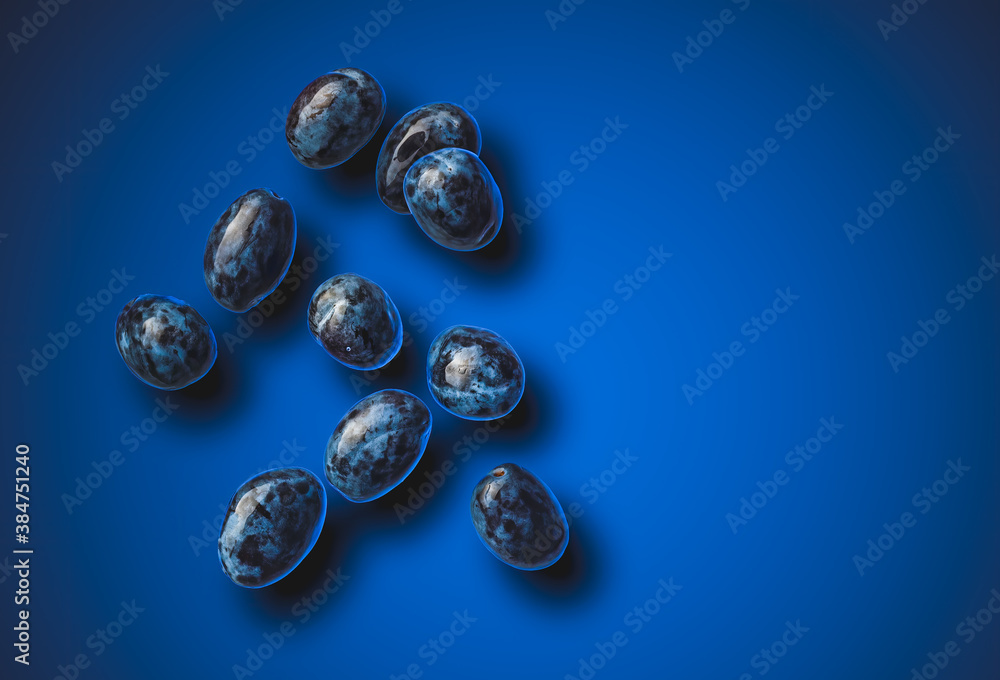 Isolated shot of plums splashing with water, isolated on blue background. Isolated shot of plums splashing with water, isolated on blue background.