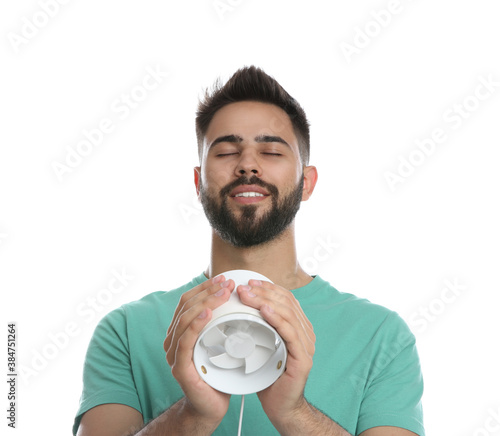 Man enjoying air flow from portable fan on white background. Summer heat