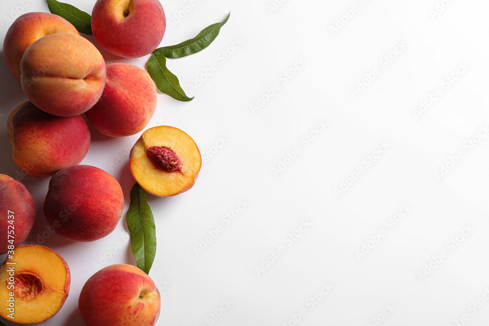 Fresh ripe peaches and green leaves on white background, flat lay. Space for text Fresh ripe peaches and green leaves on white background, flat lay. Space for text