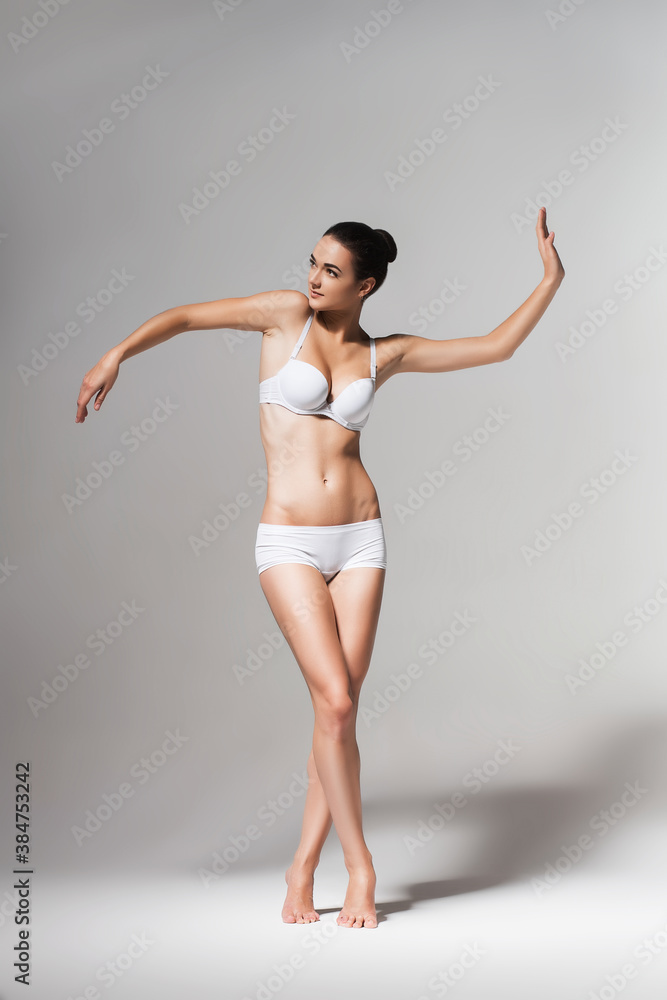 Fototapeta premium attractive dancing ballerina in white studio