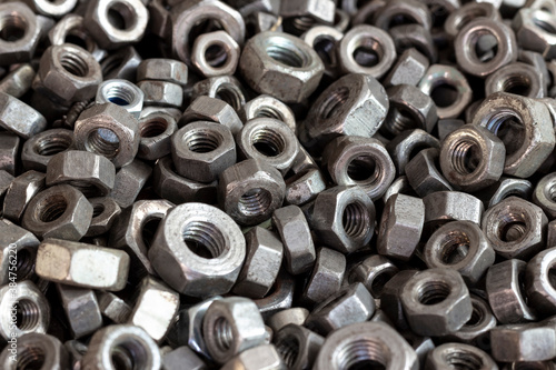 Rusty steel nuts of various sizes.