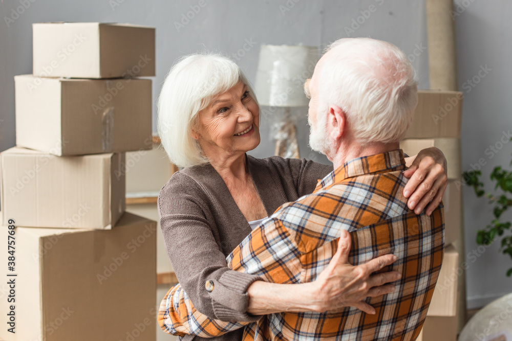 happy senior couple hugging and looking at each other in new house happy senior couple hugging and looking at each other in new house