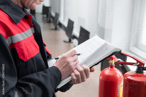 Engineer Professional are Checking A Fire Extinguisher Using Clipboard or checking Industrial fire control system,Fire Alarm controller, Fire notifier, Anti fire.System ready In the event of a fire. © silentalex88