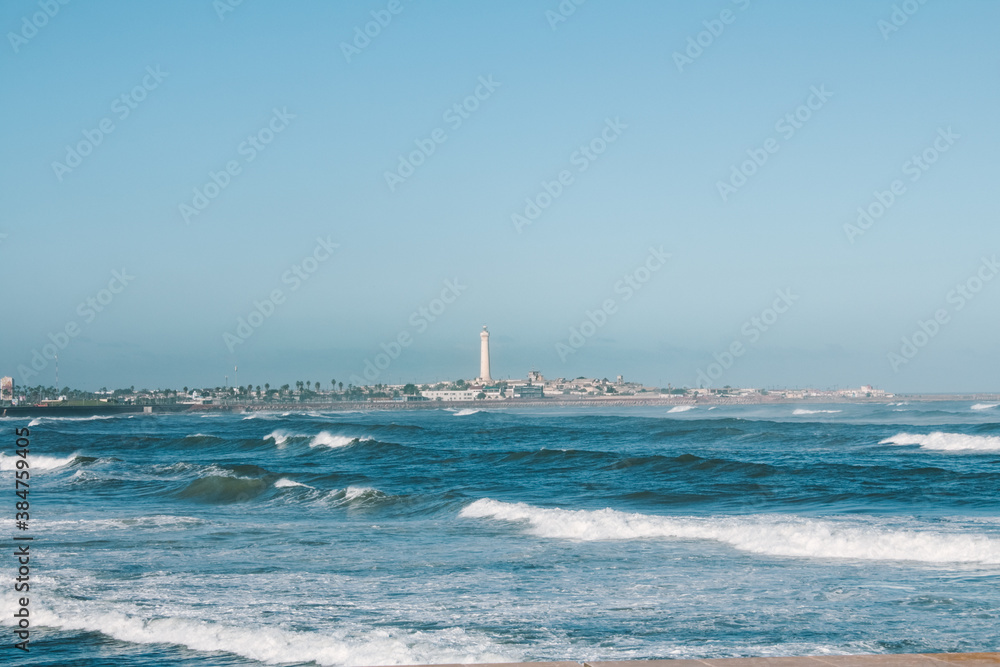 Wavy Atlantic Ocean view with lighthouse in Casablanca, Morocco, North Africa