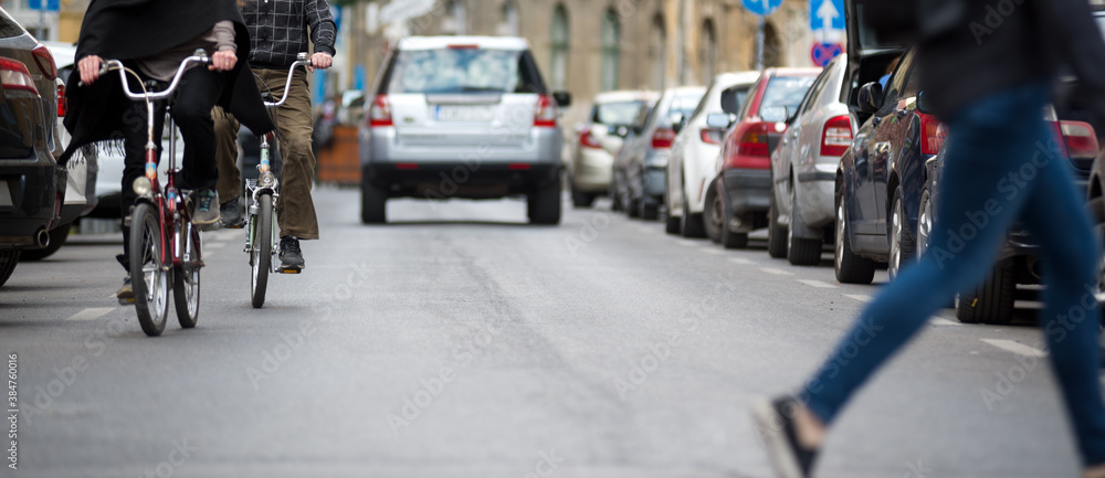 Bicycles, pedestrian and cars on the city street