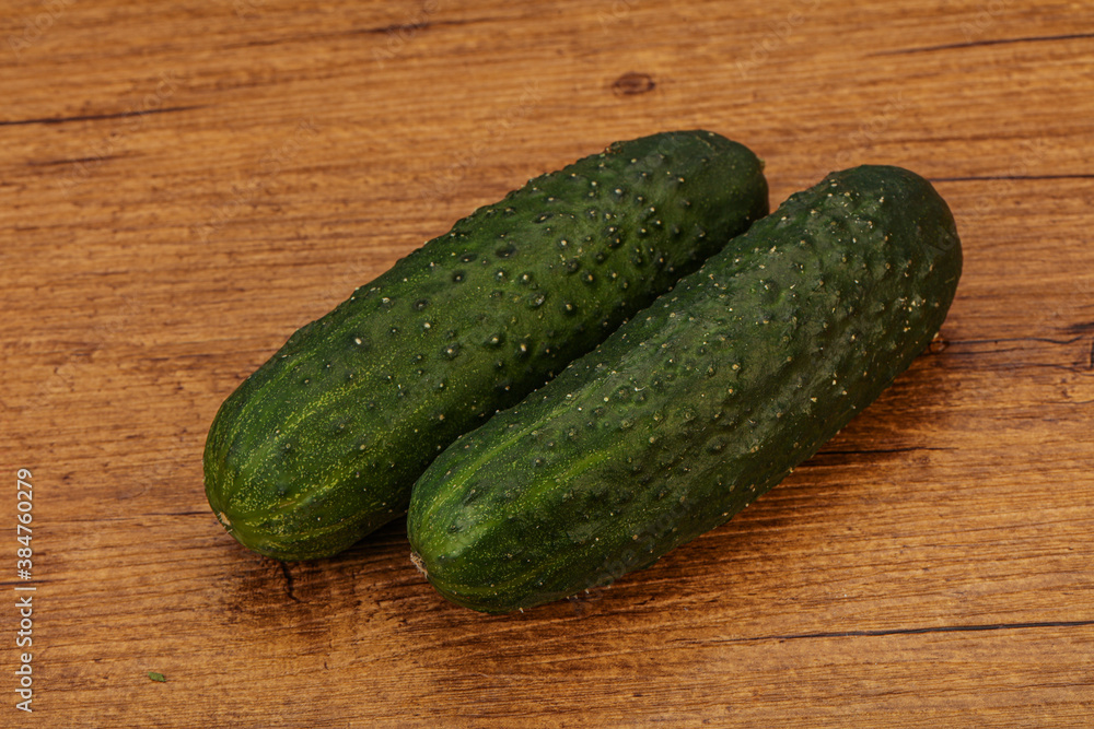 Green fresh cucumbers over background