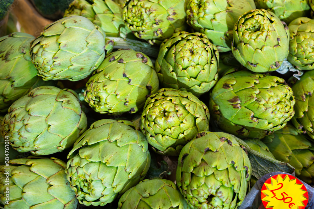 Fototapeta premium Fresh whole artichokes for sale on display of farmer market ..
