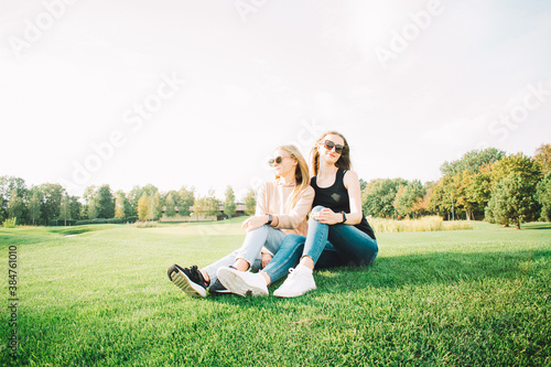 Young beautiful girls rest in the park. Stylish photo