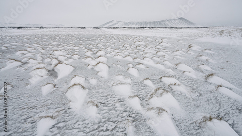 Hverfjall (also called Hverfell) tuff ring volcano by lake Mývatn. Winter mood with snow covered grass in foreground. North Iceland. photo