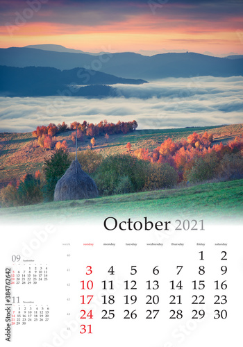 Calendar October 2021, vertical B3 size. Set of calendars with amazing landscapes. Foggy autumn view of the mountain village. Picturesque sunrise in Carpathian mountains, Ukraine, Europe.