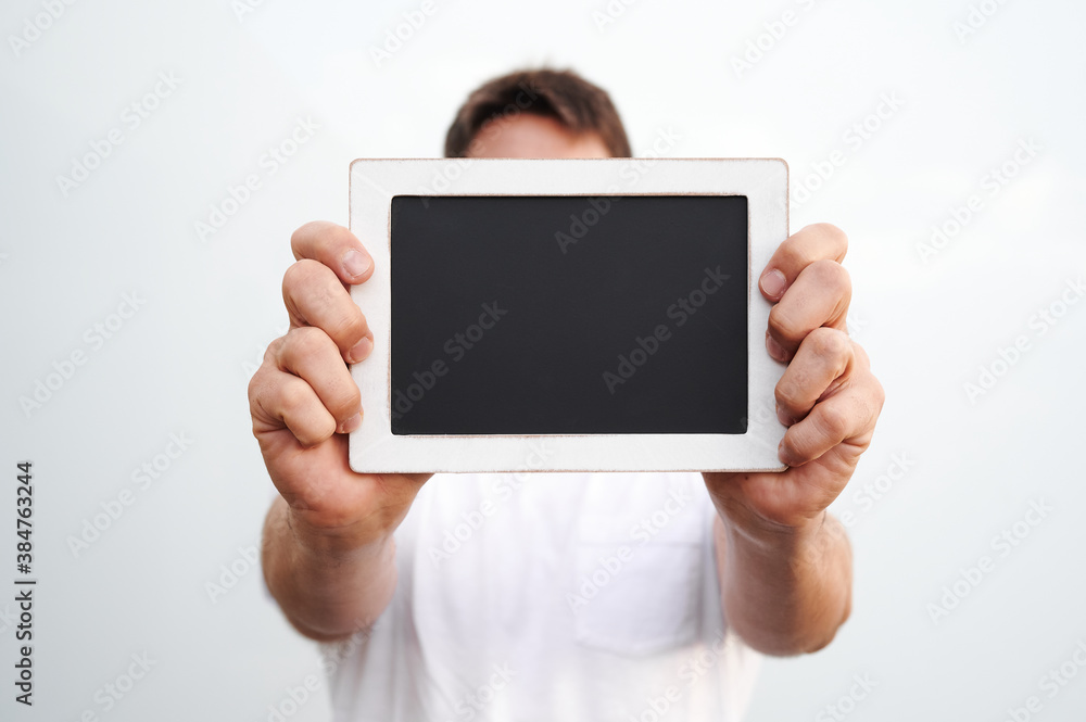 man holding chalkboard on white background