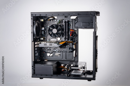 Studio shot of black Gaming desktop pc with rgb lights and visible components. Isolated on white background.