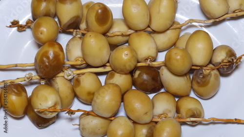 Yellow ripe dates in a white bowl