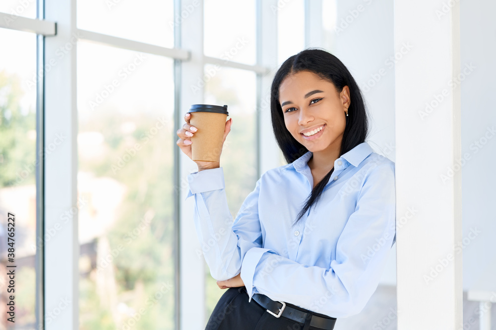 Happy black business woman with cup of coffee in hand during break time in modern office Happy black business woman with cup of coffee in hand during break time in modern office