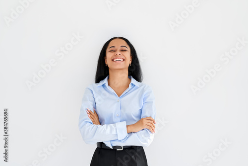 Laughing black businesswoman with crossed arms posing on white background