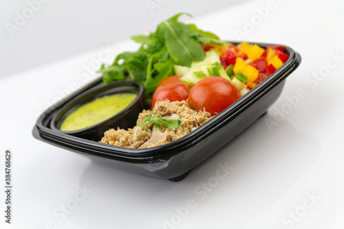 Salad with tuna, tomatoes, pepper, rocket, cucumber, sauce, white background