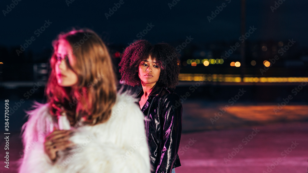 One young girl stands behind the other and looking down One young girl stands behind the other and looking down