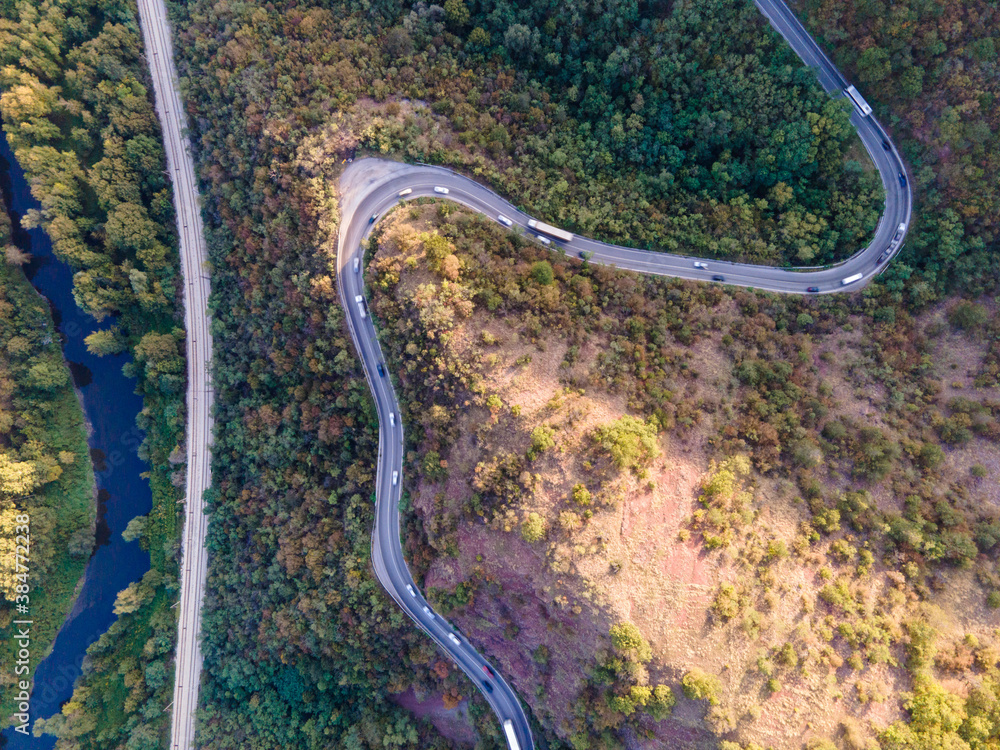 Top down aerial drone view of road with traffic in the mountain