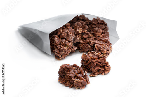 Chocolate corn flake clusters in paper bag isolated on white