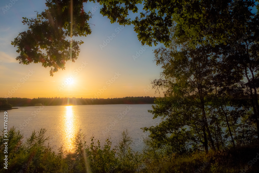 Panorama of a gorgeous sunset at a forest lake, with gold and blue color in the sky and trees reflected in the water. High quality photo Panorama of a gorgeous sunset at a forest lake, with gold and blue color in the sky and trees reflected in the water. High quality photo