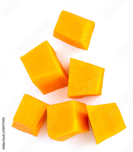Diced Pumpkin  isolated on white background.  Fresh Pumpkin pieces cut in a cube slice, top view. Flat lay.