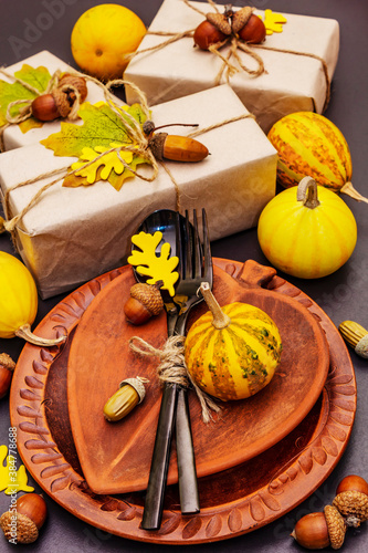 Autumn table setting with crafted gift boxes, fall decor and black cutlery