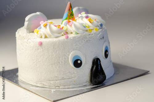 Madeira sponge layered with frosting and raspberry jam, covered in soft icing with edible decorations, koala bear-shaped cake photo