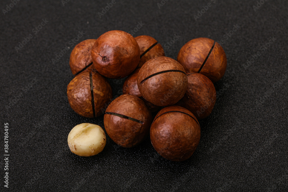 Brown macadamia nut heap over background