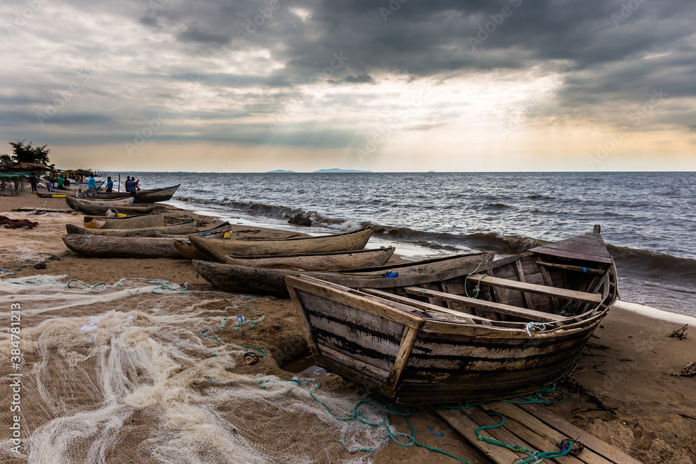 Boats on Lake Malawi beach with sun rays shining on water