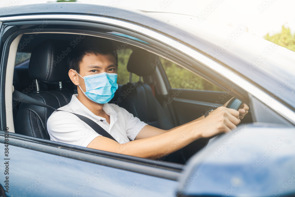 Asian businessman inside driving car automobile wearing protective surgical face mask protection from covid-19 coronavirus pandemic safety commuter traveling to work business travel social distancing Asian businessman inside driving car automobile wearing protective surgical face mask protection from covid-19 coronavirus pandemic safety commuter traveling to work business travel social distancing
