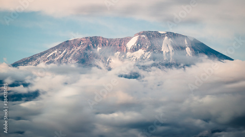 Kilimanjaro mountain peaking from clouds photo