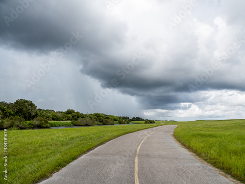 Looking down road at rain storm clouds on the horizon in Southwest Florida