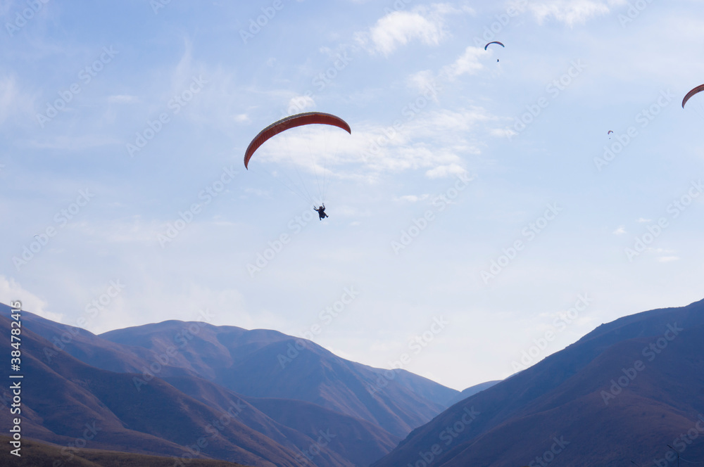 Paragliding. A man flies on a parachute against the blue sky. Paragliding. A man flies on a parachute against the blue sky.