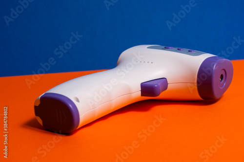 Isometric Medical Digital Non-Contact Infrared Thermometer. It measures the ambient and body temperature without contact and with colored warning symbols.