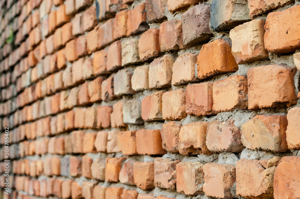 Fototapeta premium Red brick wall in receding perspective. Geometric composition of rectangular clay bricks.