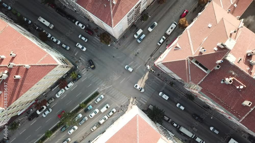 Aerial view of the city traffics at the center. Vehicles are moving on the road between buildings. Aerial view of the city traffics at the center. Vehicles are moving on the road between buildings.