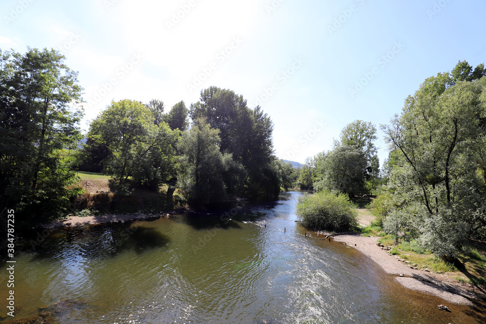 Nice view over a small wild french river in a green forest area. Photo is taken on a sunny day in summer. Nice view over a small wild french river in a green forest area. Photo is taken on a sunny day in summer.