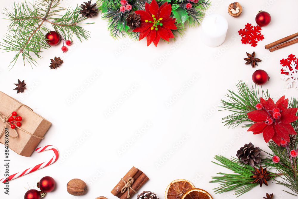 Christmas frame with festive decor of Christmas tree branches, wreath and gifts on a white background. Flat lay style Christmas frame with festive decor of Christmas tree branches, wreath and gifts on a white background. Flat lay style