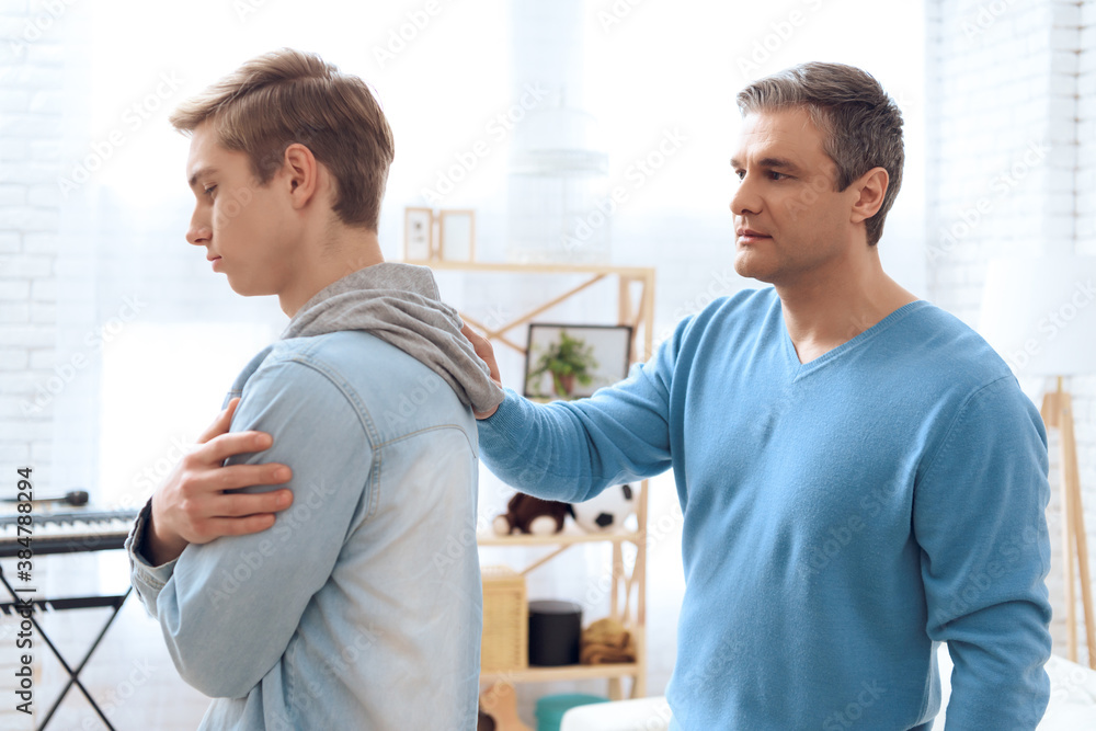 Fototapeta premium Father tries to talk to his son, but problem teenager is deep in his own thoughts.